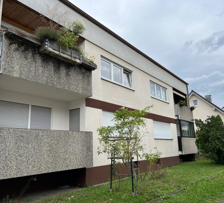 Wohnhaus mit Balkonen und bepflanztem Vorgarten in der Löwenberger Straße
